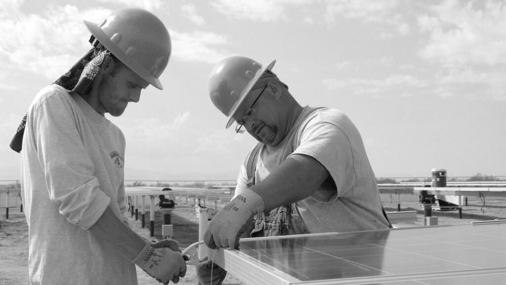 Banner alb-negru cu 2 muncitori lucrand